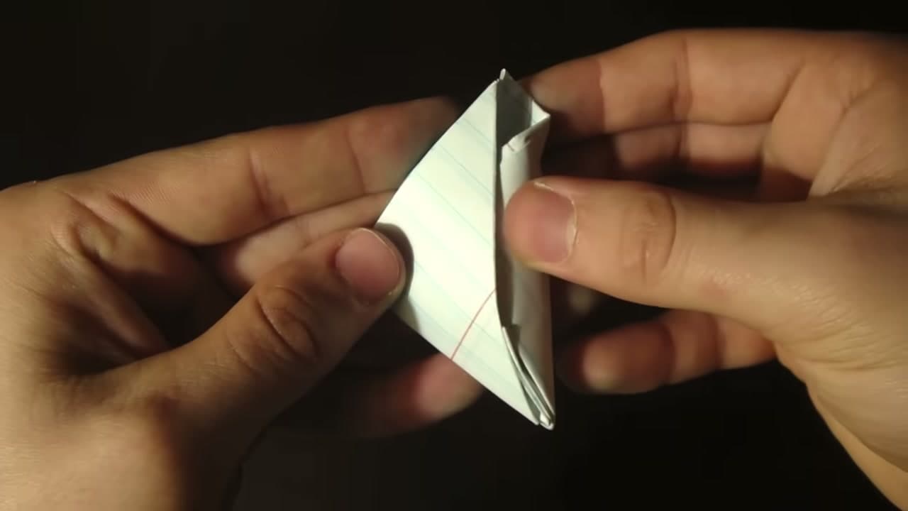 Step 8: Tuck the Leftover Tail Into the Pocket - How to Make a Paper Football (Classic Triangle Fold)